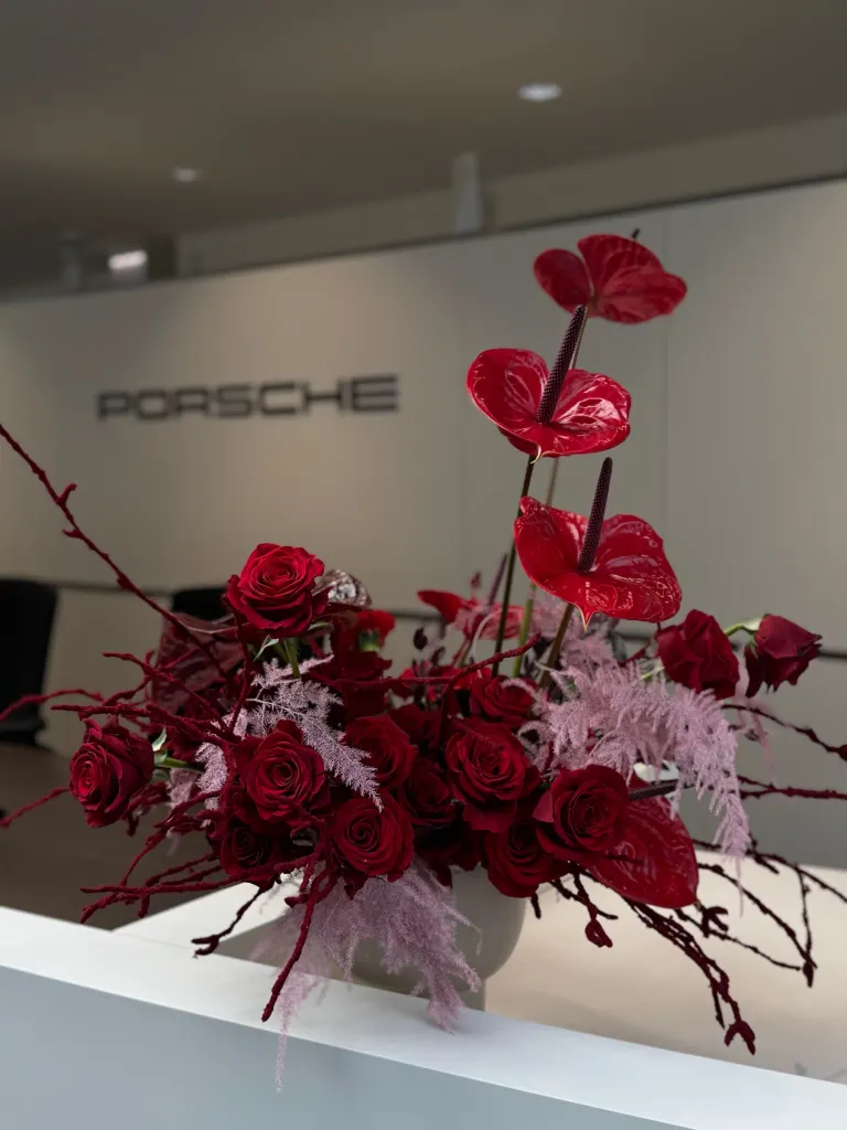 Kompozycja z czerwonym anturium i różami na ladzie salonu Porsche